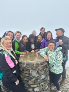 Group of home team members and young people at the snowdon summit.