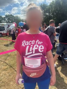 Young person in a pink t shirt after finishing the race.